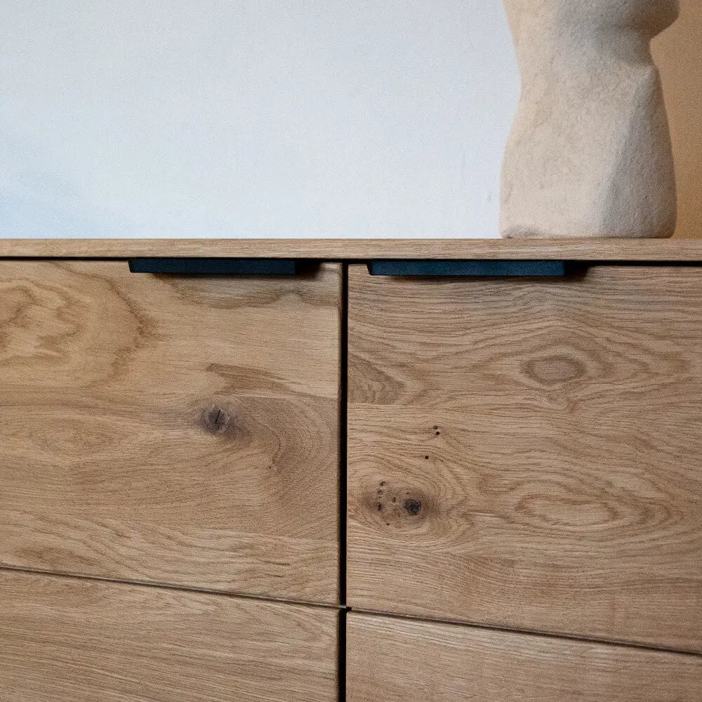 Eichenholz-Kommode mit schwarzem Griff, natürliche Maserung, modernes und minimalistisches Design.