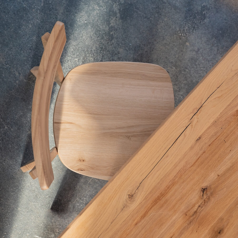 Esszimmerstuhl LUMA aus Eiche neben Massivholztisch – nachhaltiges Design für langlebige Möbelstücke