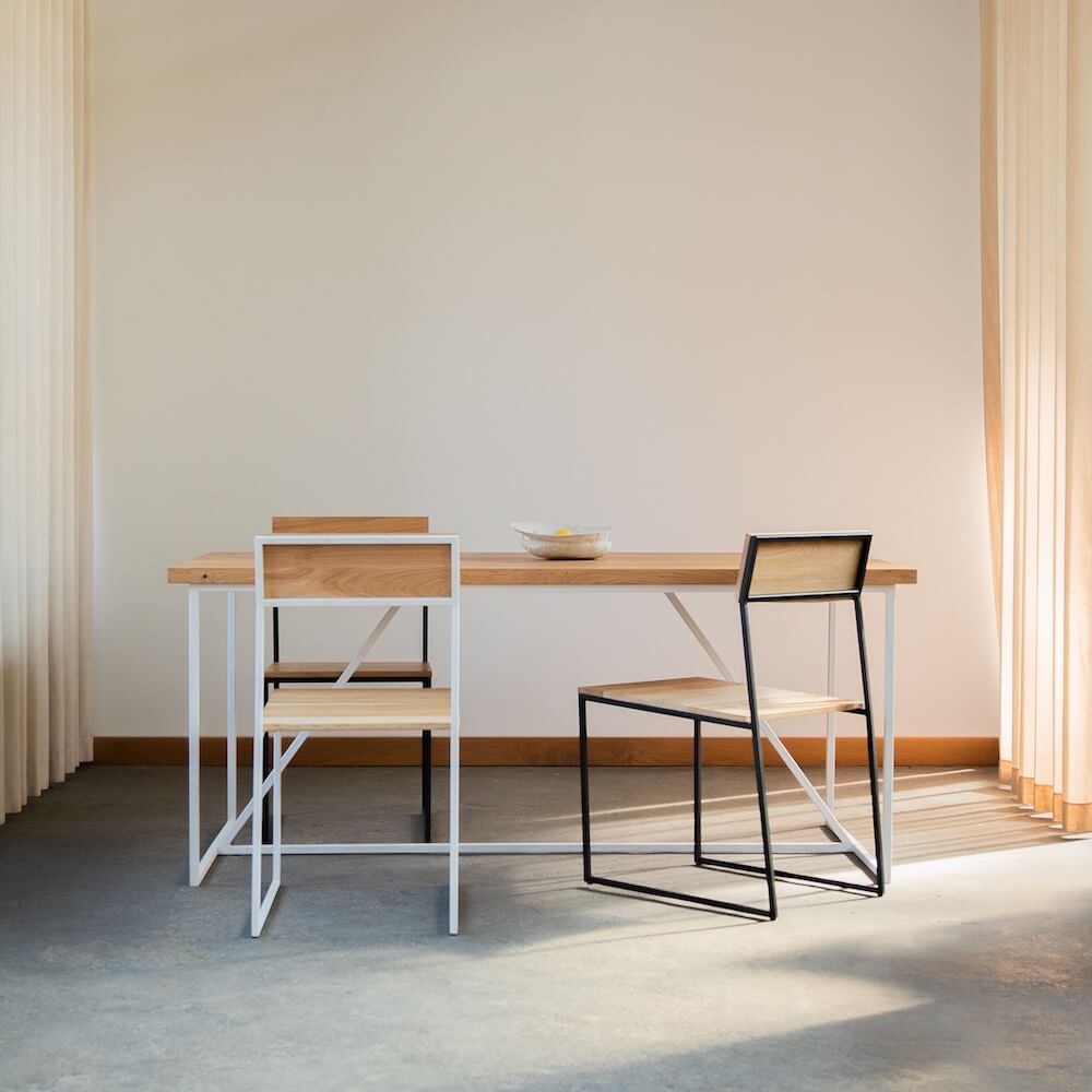 Esszimmerstuhl MILO aus Eiche mit Stahlgestell an Massivholztisch in heller, minimalistischer Umgebung