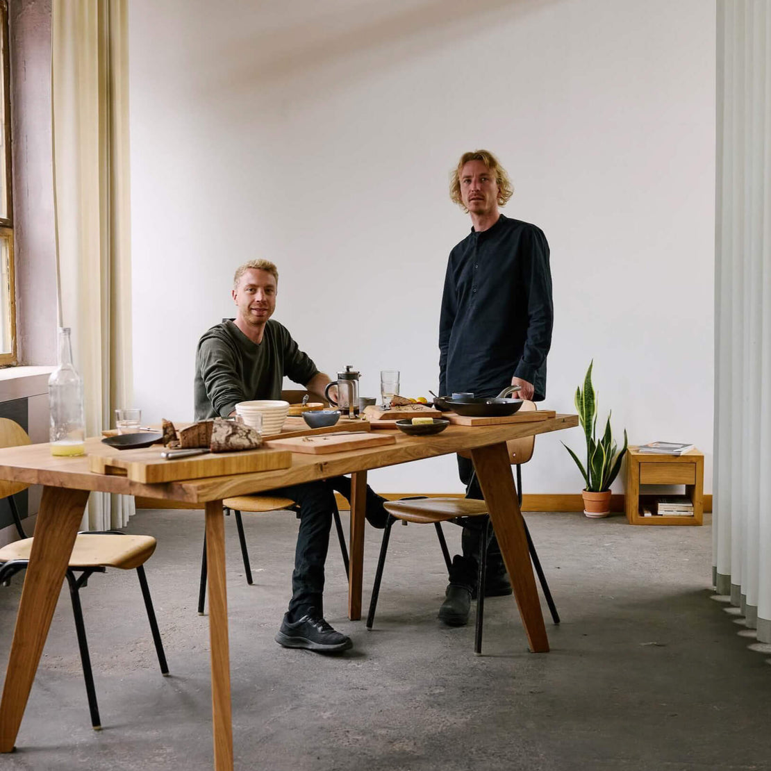 Woodboom Gründer Joschka & Mischa Olma am Massivholztisch – nachhaltige Möbel & zeitloses Design.