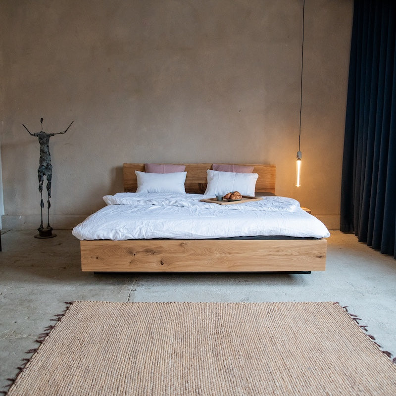 Massivholzbett aus Eiche im minimalistischen Design mit Naturmatratze und stilvoller Pendelleuchte.