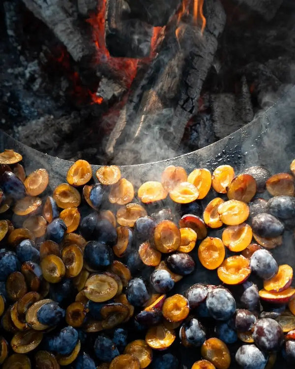 Karamellisierte Pflaumen auf Feuerring, karamellisiert über offenem Feuer – woodcuisine Naturküche Outdoor-Kochen.