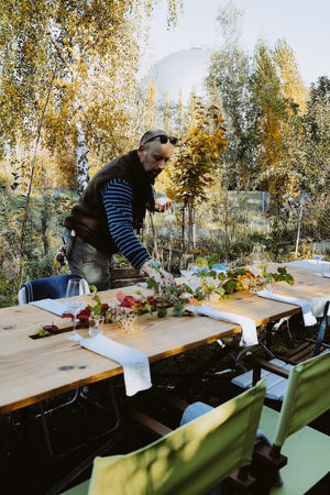 Martin Rötzel von The Monk Garden deckt einen Holztisch für ein woodcuisine-Event in der Naturküche.